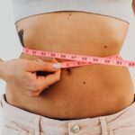 "mulher com fita métrica na cintura — como acelerar o metabolismo e emagrecer"